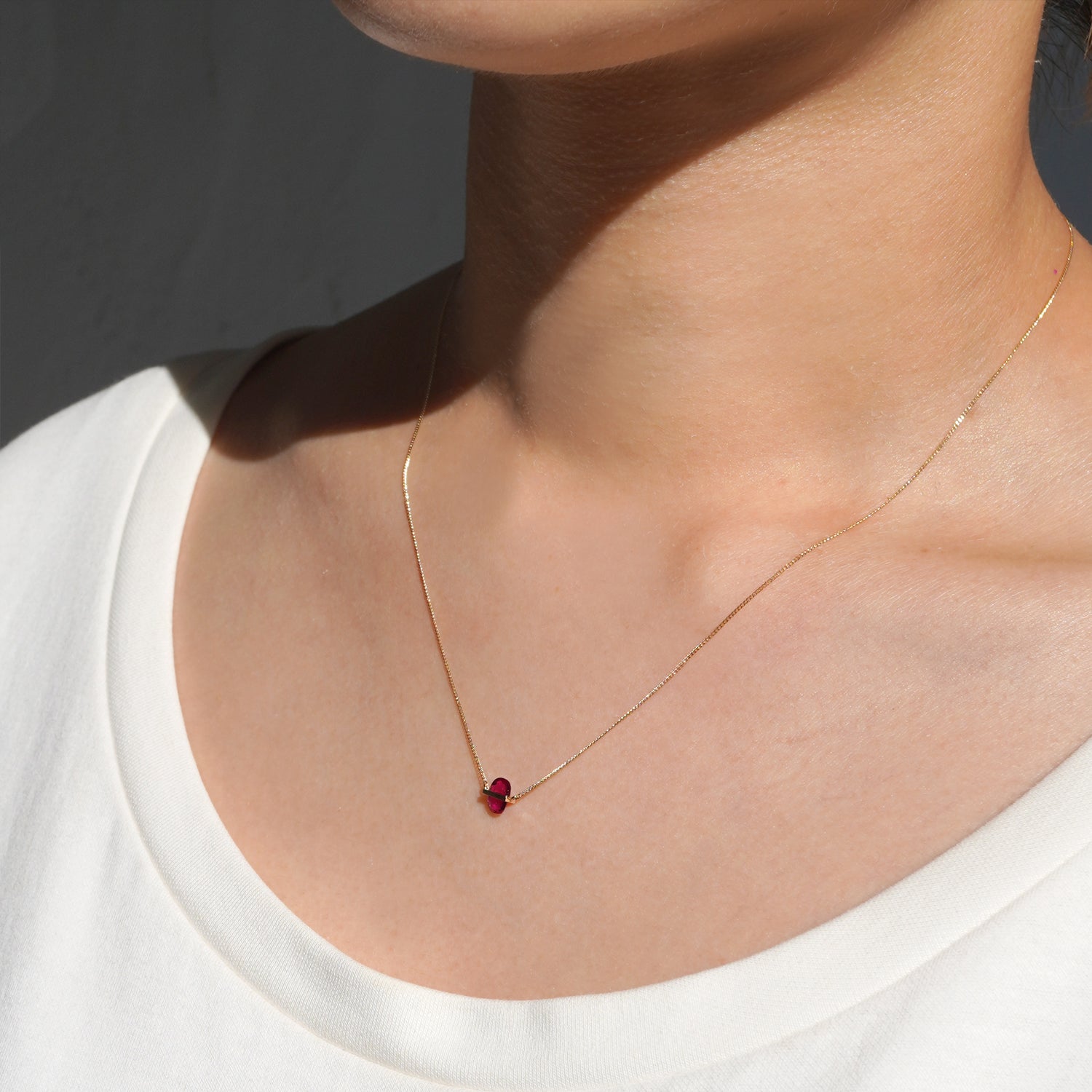 RUBY(ルビー)の天然石を横断するようにバーで固定したゴールド(K10YG)ネックレス、右側からの着用
