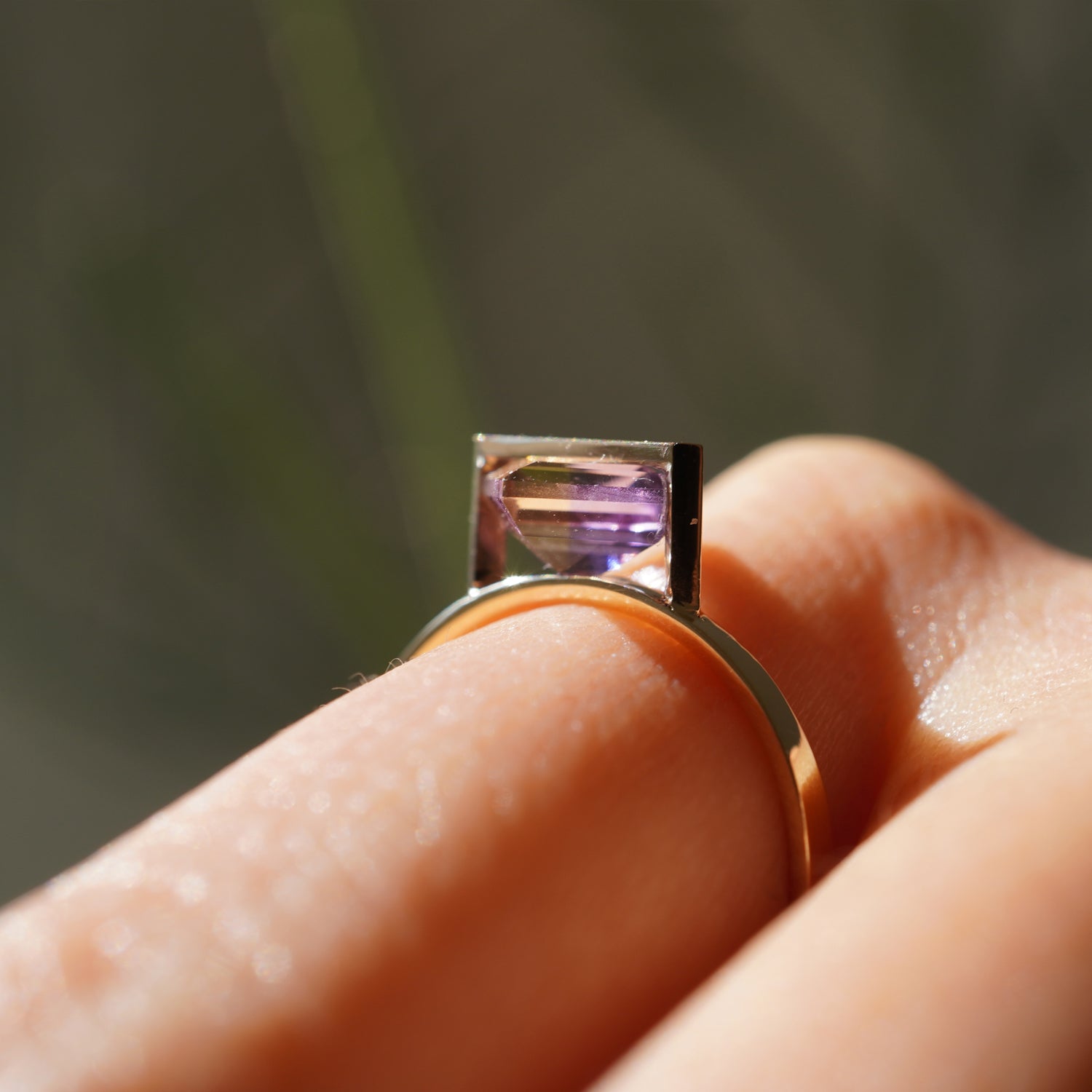 菱形のアメトリンをセットしたK10イエローゴールドリングのサイドから見た着用イメージ、石留めの構造がわかりやすいイメージ。