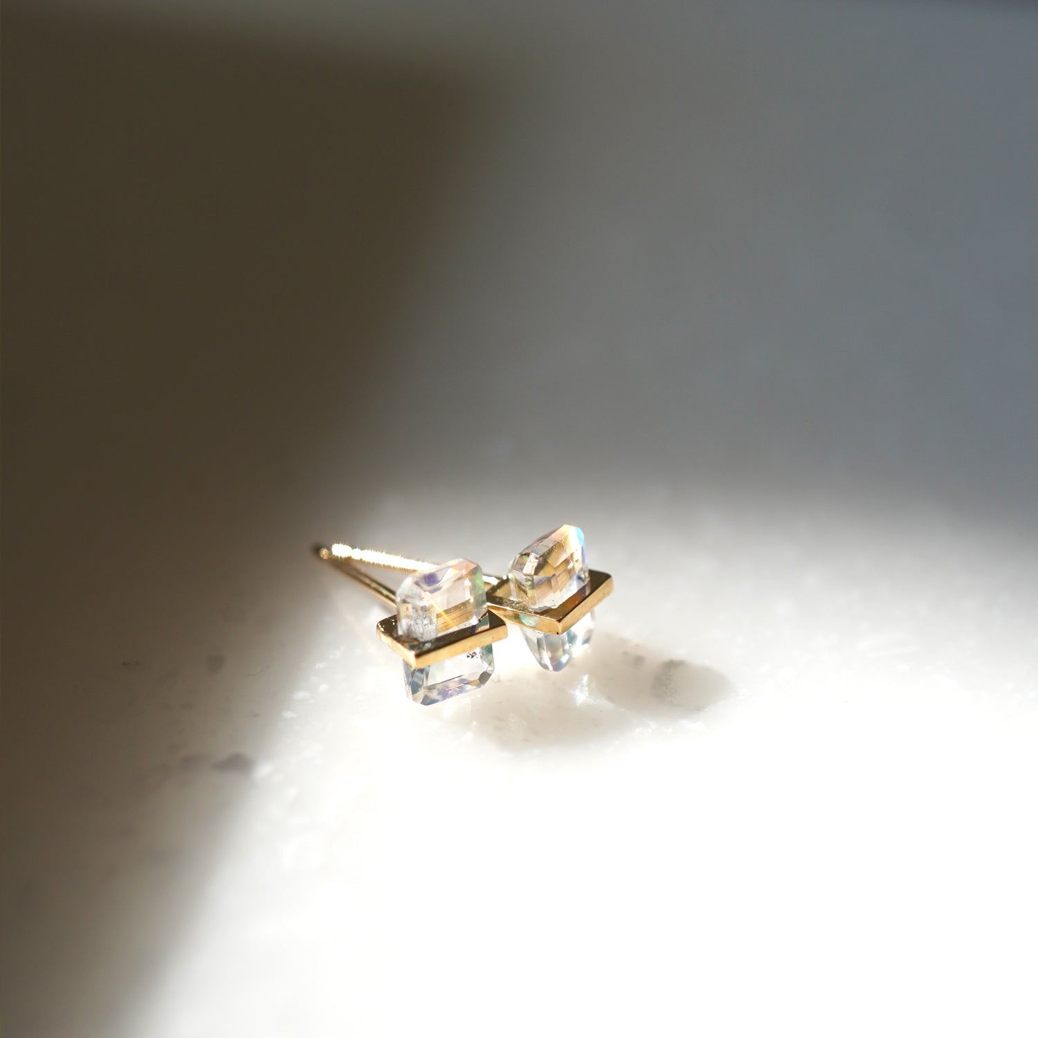 バケットカットのレインボームーンストーンをセットしたピアス(ペア)、優しい光の中で見たムーンズトーン