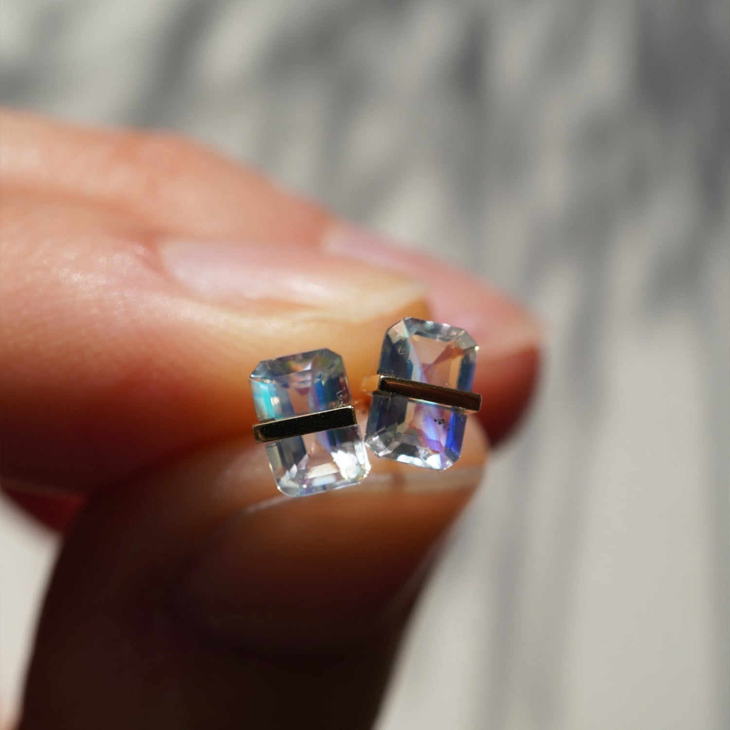 光の角度で虹色に変化するレインボームーンストーンの遊色が際立つピアス(ペア)