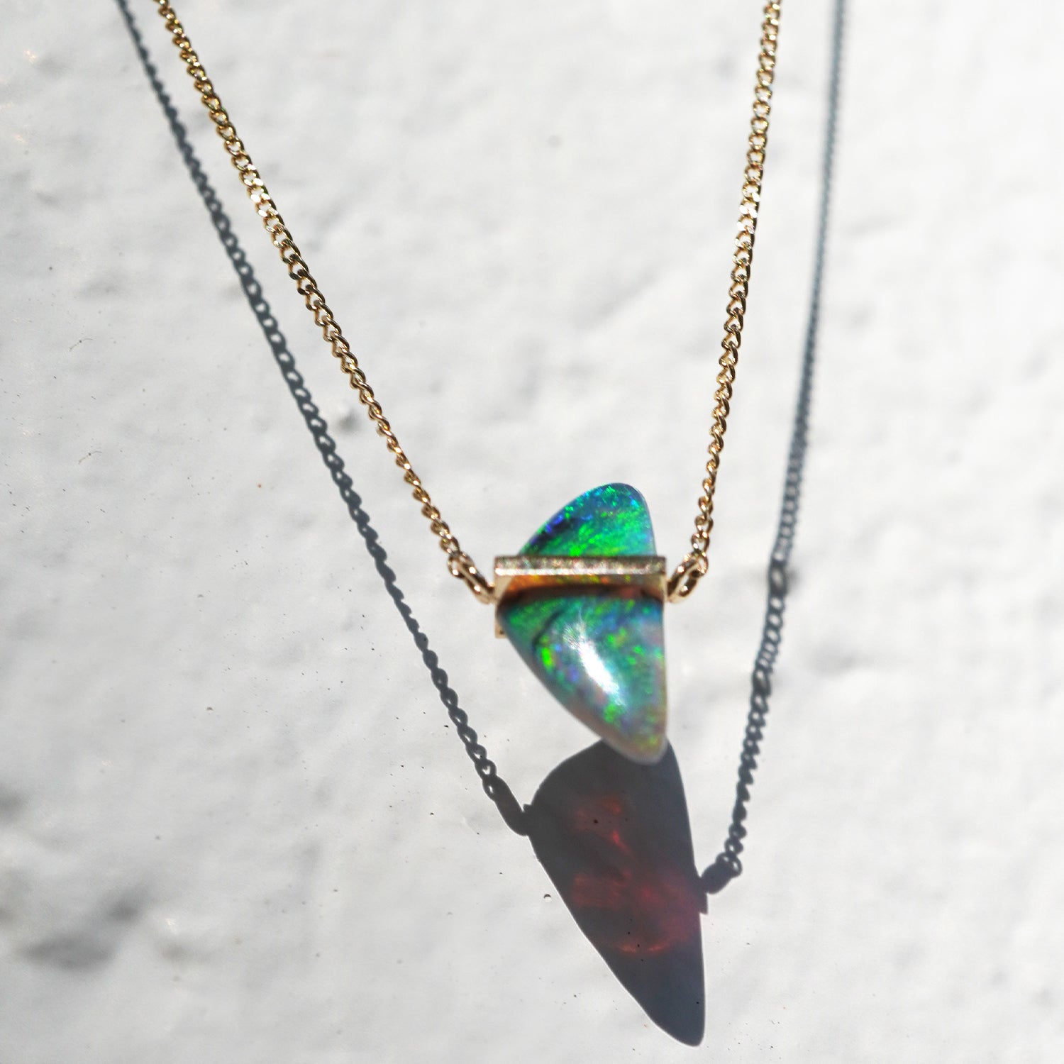 ボルダーオパールの遊色と表面の質感がわかるK10イエローゴールドネックレスのしたから見たクローズアップ