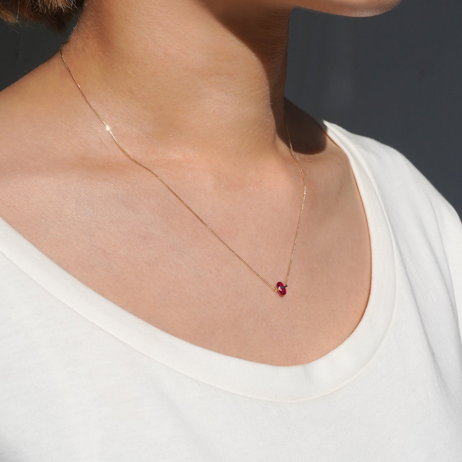 RUBY(ルビー)の天然石を横断するようにバーで固定したゴールド(K10YG)ネックレス、左から見た時の着用