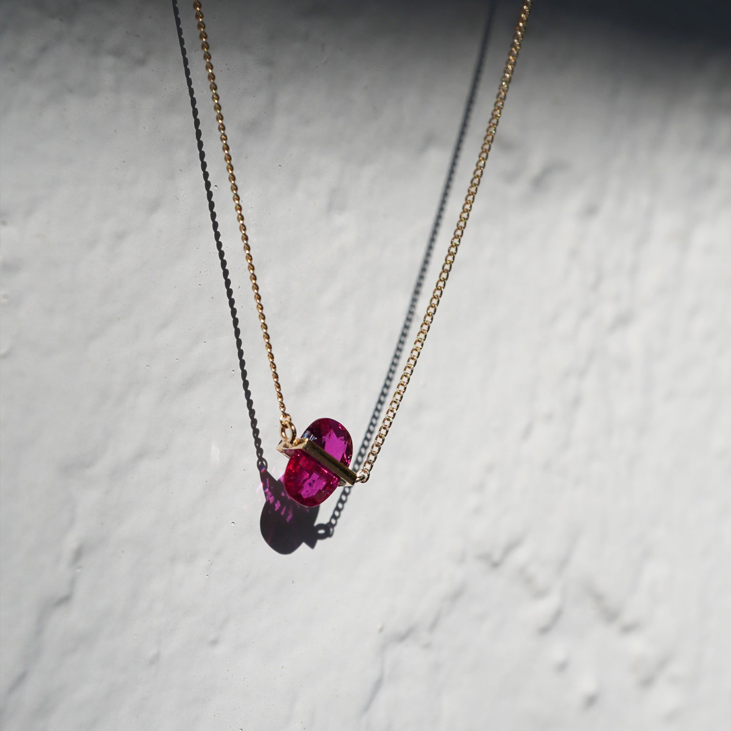 RUBY(ルビー)の天然石を横断するようにバーで固定したゴールド(K10YG)ネックレス、少し下からのアングルで透明感が綺麗