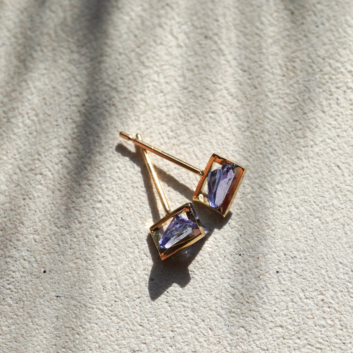 三角形にカットされたタンザナイトの青紫が美しいK10イエローゴールドのピアス(ペア)、真上から見たイメージ。