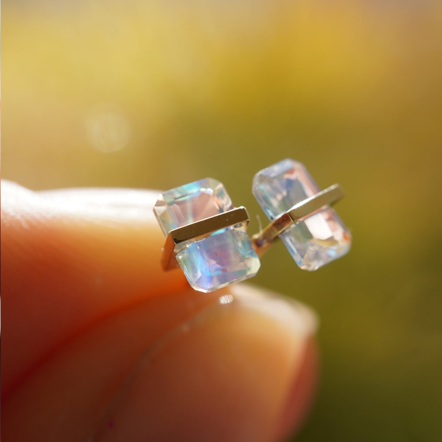 バケットカットのレインボームーンストーンの遊色が美しいピアス（ペア）、光の角度で色が変化するデザイン