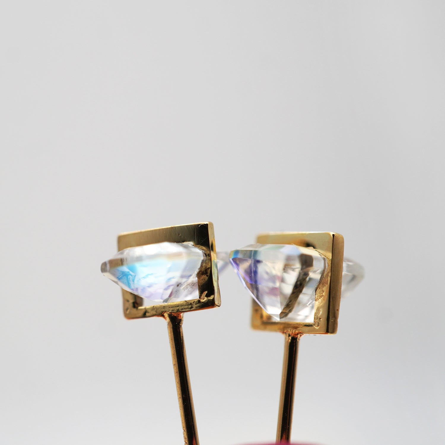 レインボームーンストーンの遊色と透明感が際立つピアスのクローズアップ（バケットカット・ペア）