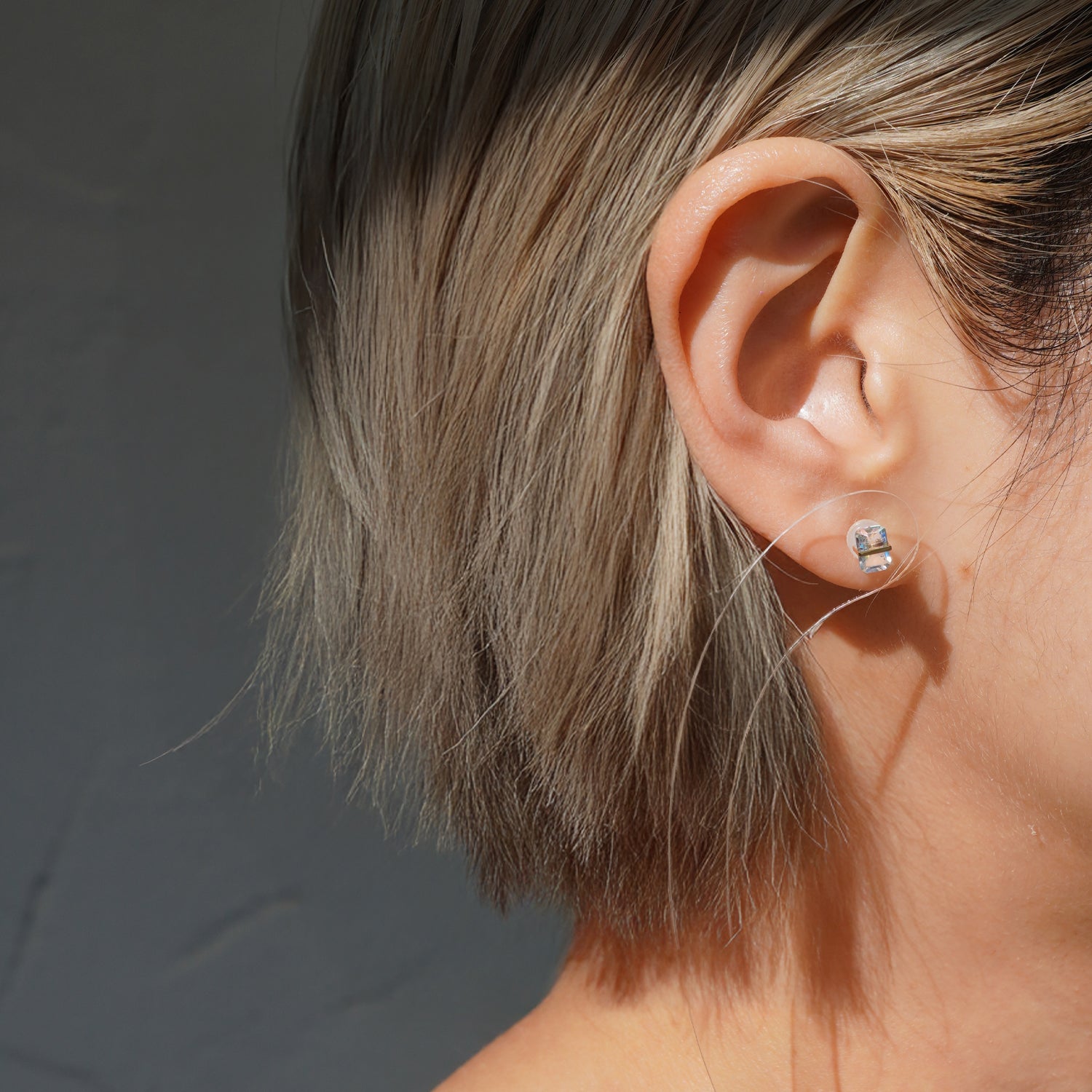 レインボームーンストーンピアスの着用イメージ、耳元で遊色が見えるバケットカットデザイン（ペア）