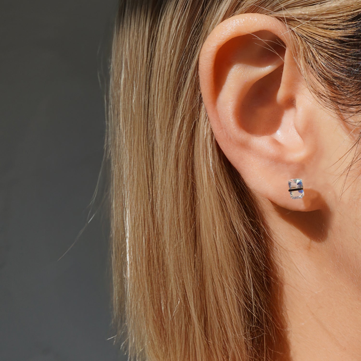 レインボームーンストーンピアスの着用イメージ、耳元で遊色が見えるバケットカットデザイン（ペア）