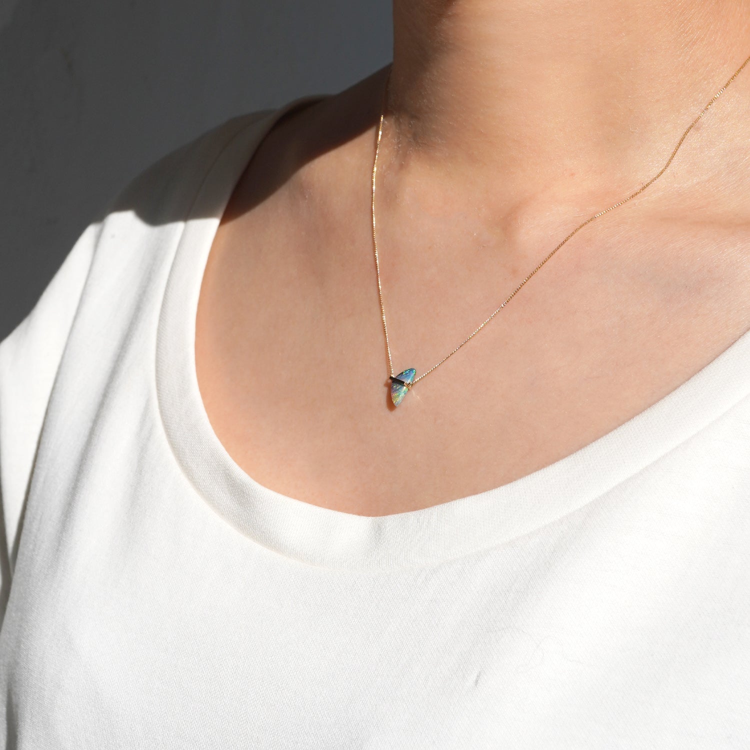 ボルダーオパールをセットしたK10イエローゴールドネックレスの向かって右から見た着用イメージ、40cmの長さ感