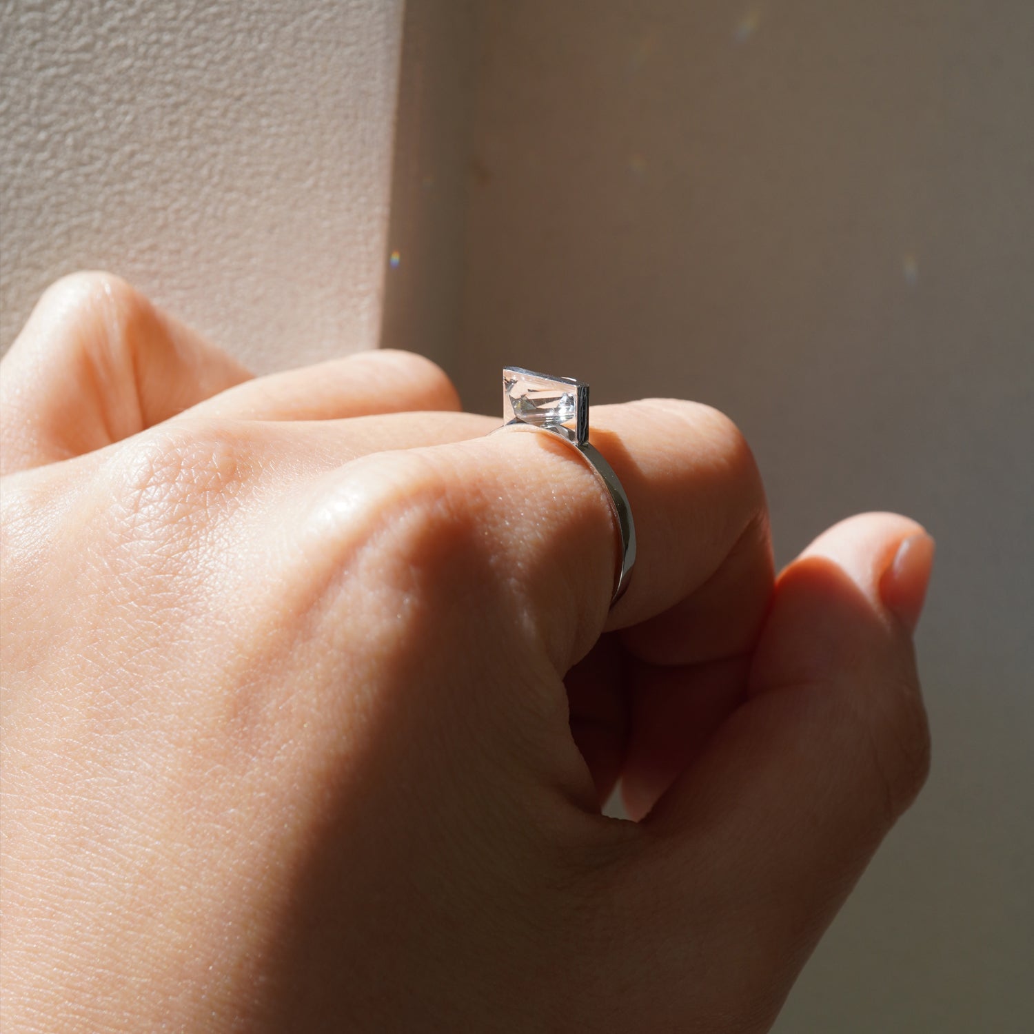 菱形カットのクオーツの透明感が際立つPt900リングの着用イメージ、横から見ると構造がわかりやすい。