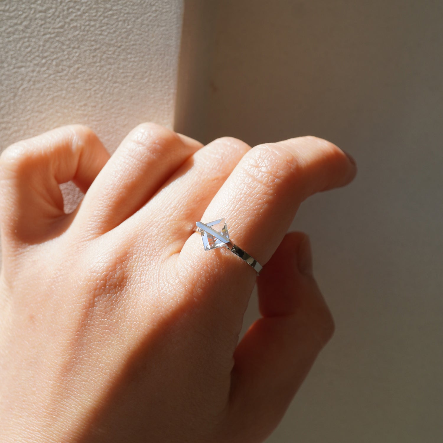 菱形カットのクオーツの透明感が際立つPt900リングの引きで見た着用イメージ、バーで固定した構造（11号）