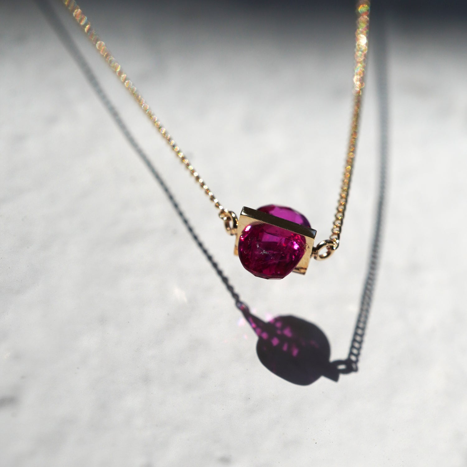 RUBY(ルビー)の天然石を横断するようにバーで固定したゴールド(K10YG)ネックレス、下からのアングルで構造の面白さがわかりやすい