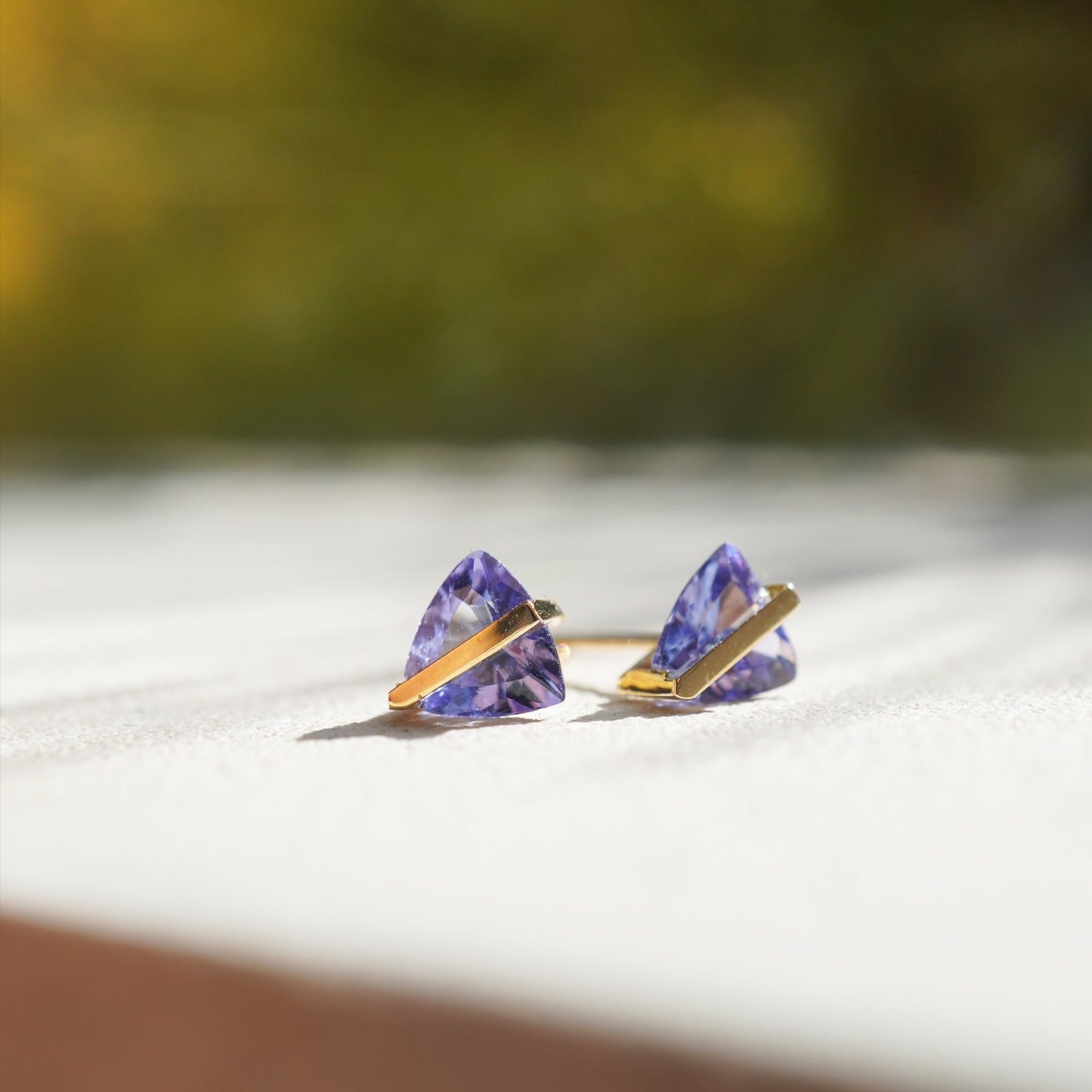 三角形のタンザナイトをセットしたK10イエローゴールドのピアス（ペア）、ポストはK18イエローゴールド仕様のミニマルなデザイン